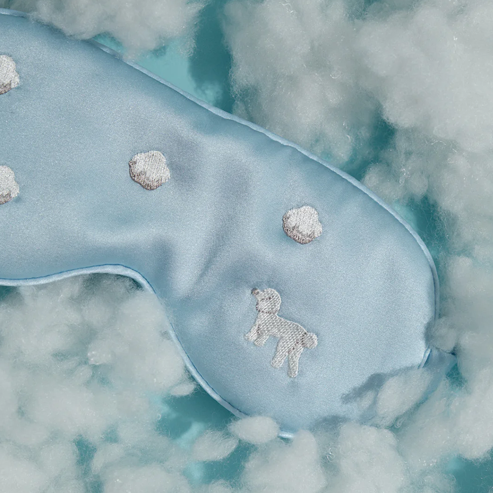 Close up of light blue silk sleep mask in fluffy clouds