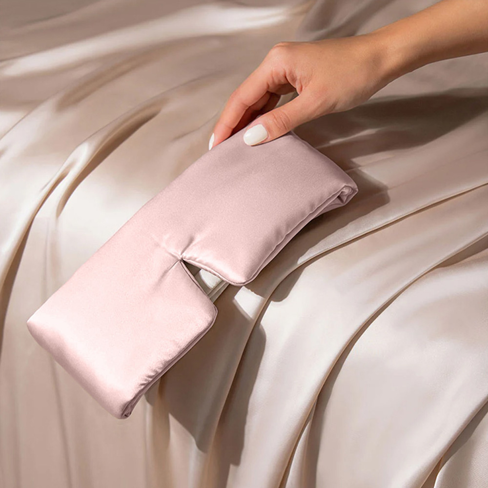Pink silk wrap sleep mask on luxury silk bedding