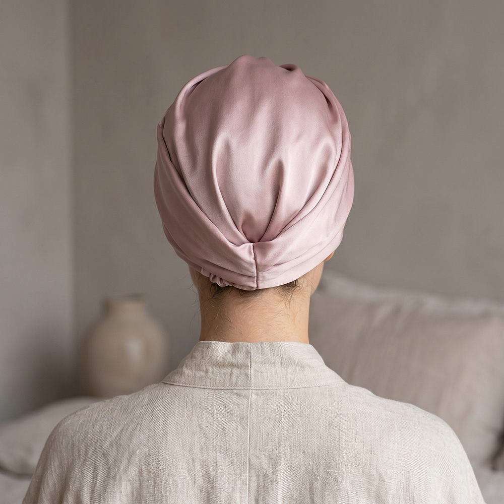 Back view of woman wearing pink silk sleep turban
