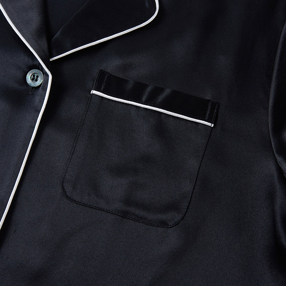 Chest pocket and button detail with white piping on silk pajama top