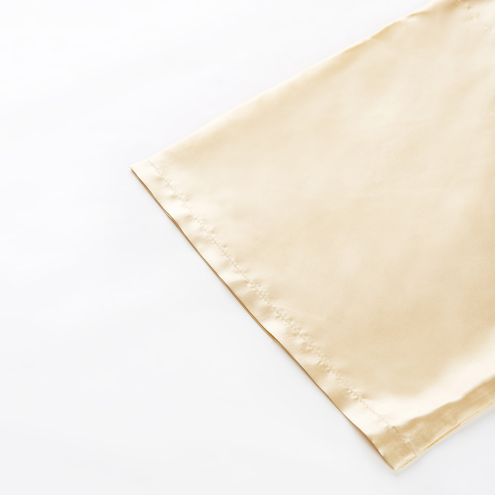 Wide sleeve hem detail on golden silk bathrobe
